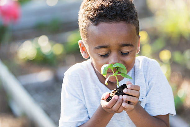 Little boy snuggling a baby plant